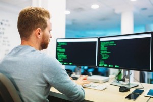 Portrait of young programmer working in office